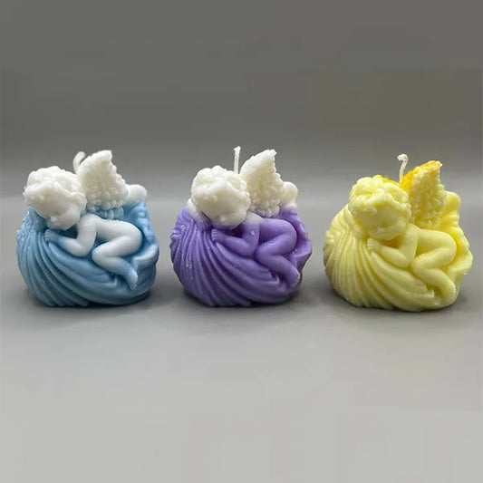 Set van drie handgemaakte engelen geurkaarsen in violet, blauw en geel – sfeervol gepresenteerd.